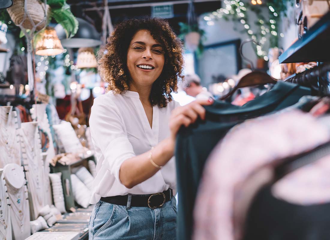 Retail Business Insurance - Female Customer Enjoying Shopping in Brand New Trendy Retail Store and Buying Stylish Clothing While Smiling at Camera