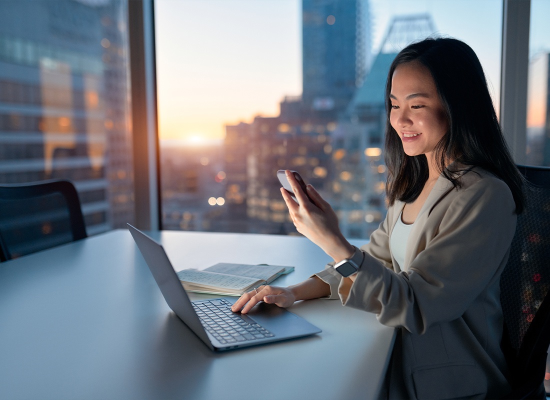 Read Our Reviews - Young Woman Looking at Her Phone While Working